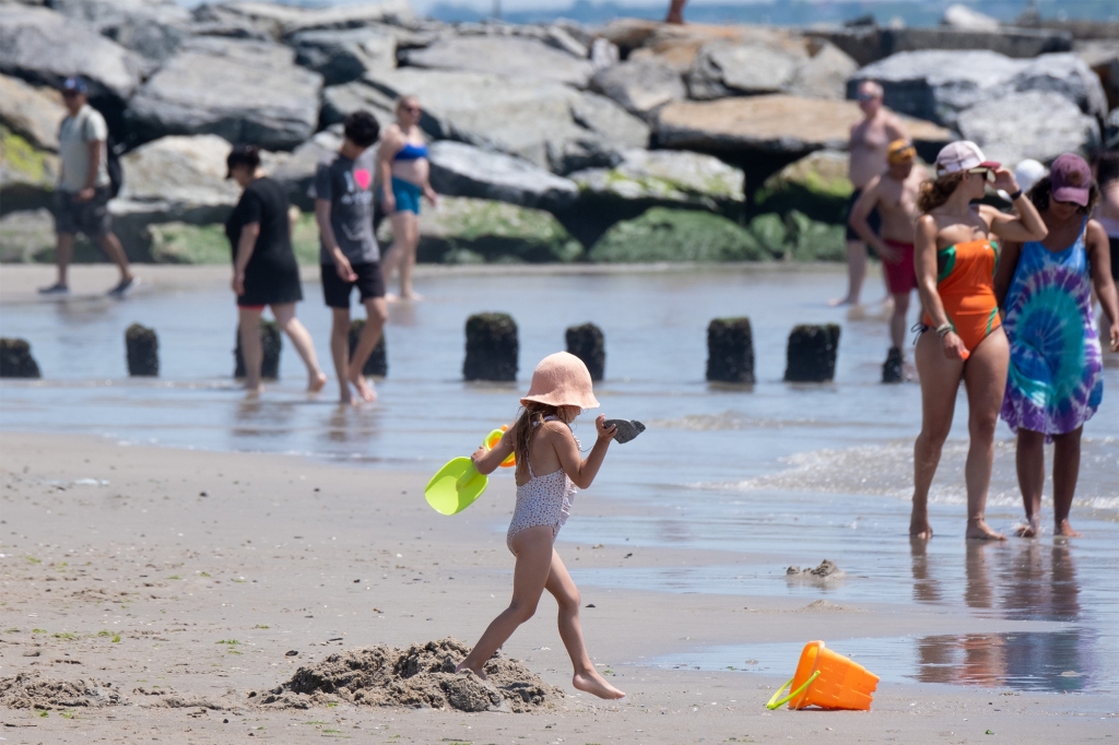 A girl digs a hole in the sand.