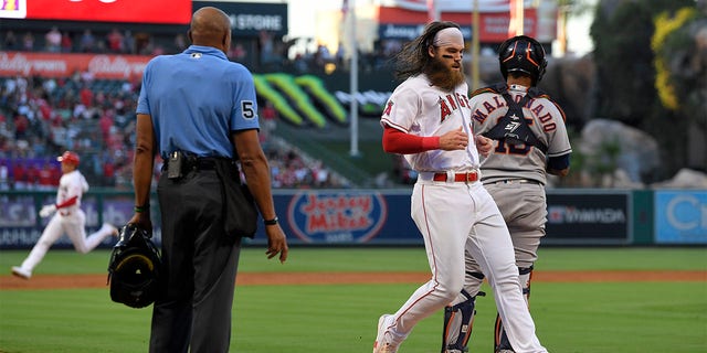 Los Angeles Angels' Brandon Marsh, second from right, scores on a triple by Shohei Ohtani, left, as Houston Astros catcher Martin Maldonado stands at the plate during the second inning of a baseball game Wednesday, July 13, 2022, in Anaheim, Calif. 