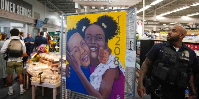 A painting titled "Hope" by Senia Che is on display as dignitaries and members of the media tour the newly renovated Tops Friendly Markets on Jefferson Avenue in Buffalo, N.Y.