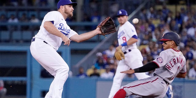 Washington Nationals' Cesar Hernandez, right, steals second as Los Angeles Dodgers third baseman Max Muncy takes a late throw from home during the fourth inning of a baseball game Monday, July 25, 2022, in Los Angeles. 