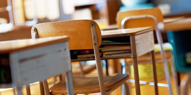 Classroom with empty wooden desks. (iStock)