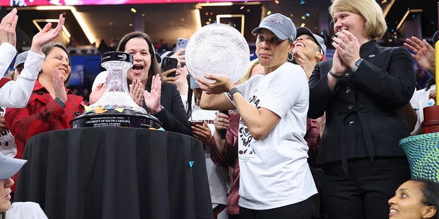 Head coach Dawn Staley of the South Carolina Gamecocks receives the WBCA coaches trophy after defeating the UConn Huskies during the championship game of the NCAA Women’s Basketball Tournament at Target Center on April 3, 2022 in Minneapolis, Minnesota.