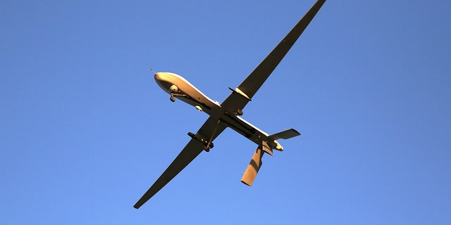 A U.S. Air Force MQ-1B Predator unmanned aerial vehicle (UAV), carrying a Hellfire missile flies over an air base after flying a mission in the Persian Gulf region on January 7, 2016. 