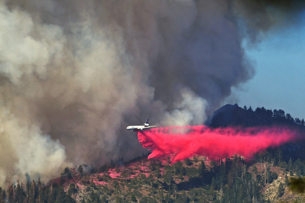 A plane drops fire retardant on the Washburn Fire as it burns near the Mariposa Grove of giant sequoias and the south entrance of Yosemite National Park, in California, Monday, July 11, 2022.