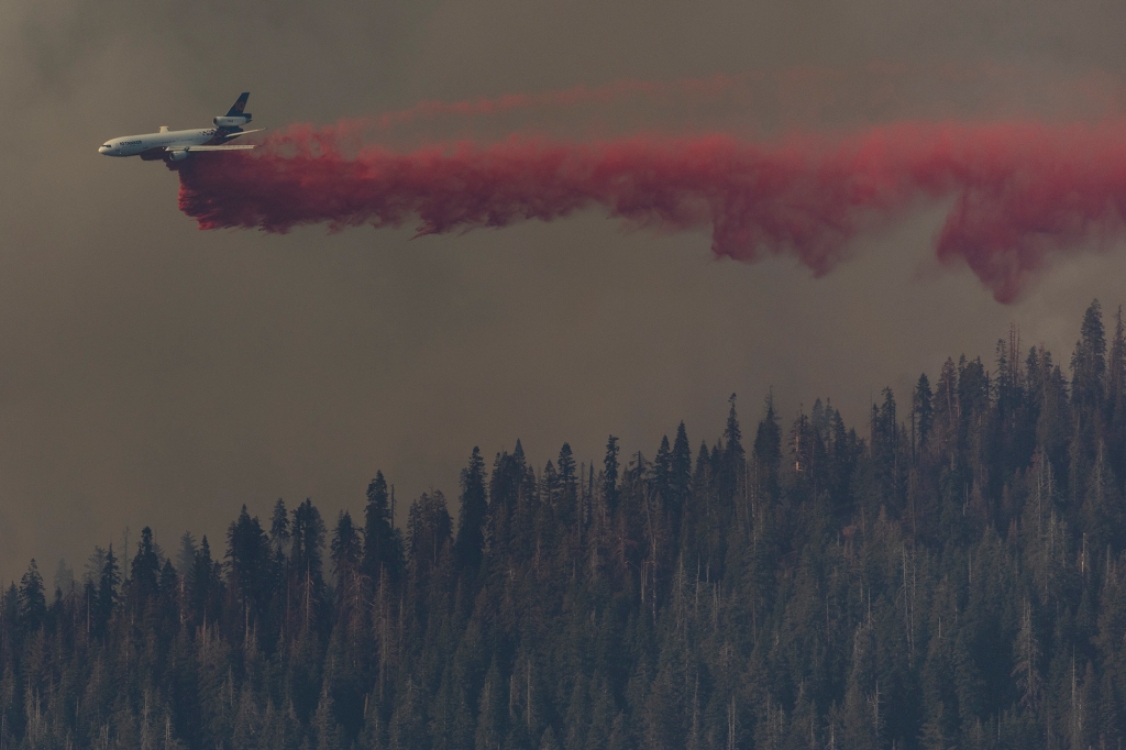 An air tanker makes a retardant drop while battling the Washburn Fire in Yosemite National Park, Calif., Monday, July 11, 2022.