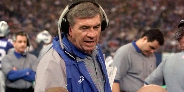 Detroit Lions coach Gary Moeller, top, talks with centers Eric Beverly, left, and Mike Compton, right, in the third quarter of an NFL football game against the Atlanta Falcons, Nov. 12, 2000, in Pontiac, Mich. Former Michigan, Illinois and Lions coach Moeller died Monday, July 11, 2022. He was 81. The University of Michigan announced his death, and no cause was provided. 