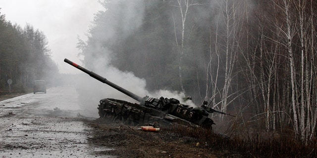 Smoke rises from a Russian tank destroyed by Ukrainian forces, on the side of a road in Lugansk region on February 26, 2022. 