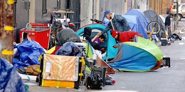 Homeless people consume illegal drugs in an encampment along Willow St. in the Tenderloin district on Thursday, Feb. 24, 2022 in San Francisco, California. 