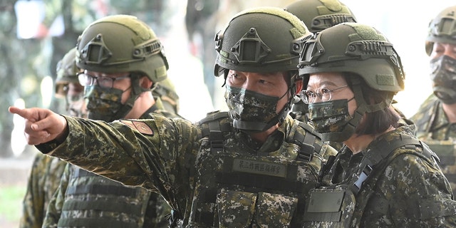 Taiwan President Tsai Ing-wen (R) listens while inspecting reservists training at a military base in Taoyuan on March 12, 2022. (Photo by Sam Yeh / AFP) (Photo by SAM YEH/AFP via Getty Images)