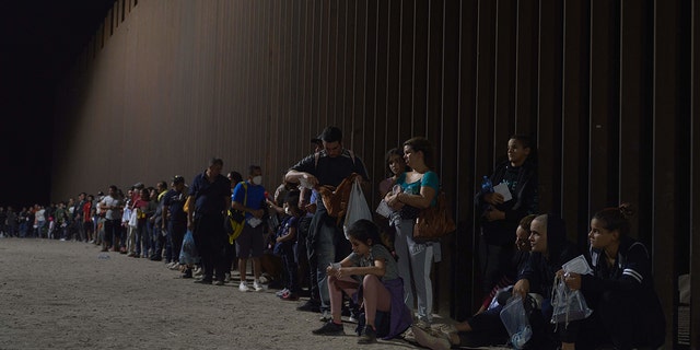 Migrants wait to be processed by US Border Patrol after illegally crossing the US-Mexico border in Yuma, Arizona in the early morning of July 11, 2022. 