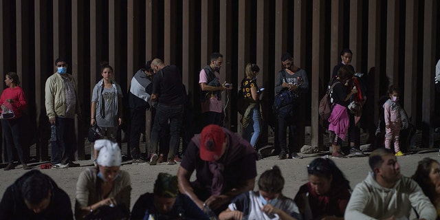 Migrants wait to be processed by US Border Patrol after illegally crossing the US-Mexico border in Yuma, Arizona in the early morning of July 11, 2022. 