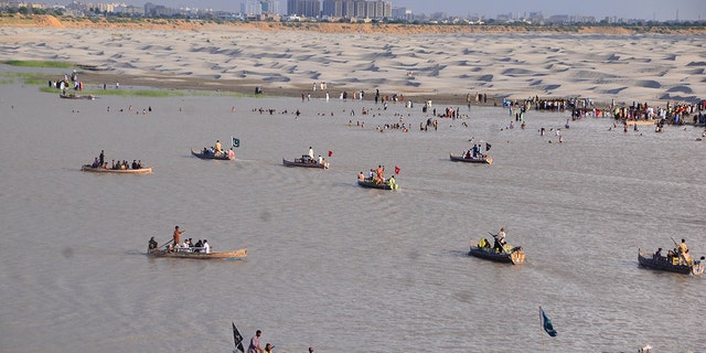 HYDERABAD, PAKISTAN - JULY 12: Pakistani people at the bank of Pakistan's largest Indus River in Hyderabad, southern Sindh province, Pakistan on July 12, 2022. (Photo by Shkeel Ahmed/Anadolu Agency via Getty Images)