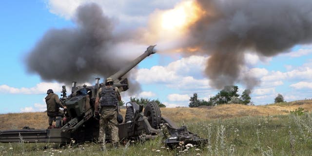 Ukrainian servicemen fire a towed howitzer in eastern Ukraine July 18, 2022.