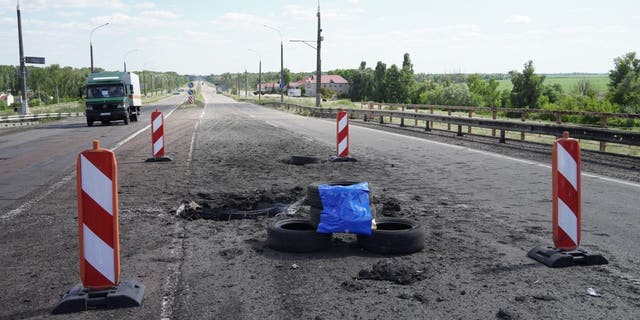 A picture taken on July 21, 2022 shows craters on Kherson's Antonovsky bridge across the Dnipro river caused by a Ukrainian rocket strike, amid the ongoing Russian military action in Ukraine. 