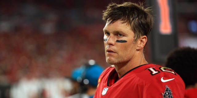 Tom Brady, #12 of the Tampa Bay Buccaneers, watches from the sidelines during the 2nd quarter of the game against the New Orleans Saints at Raymond James Stadium on December 19, 2021 in Tampa, Florida. 