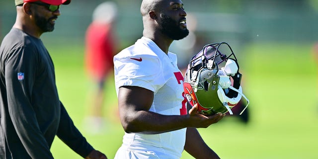 Leonard Fournette #7 of Tampa Bay Buccaneers walks with running backs coach Todd McNair during the 2022 Buccaneers minicamp at AdventHealth Training Center on June 08, 2022 in Tampa, Florida. 