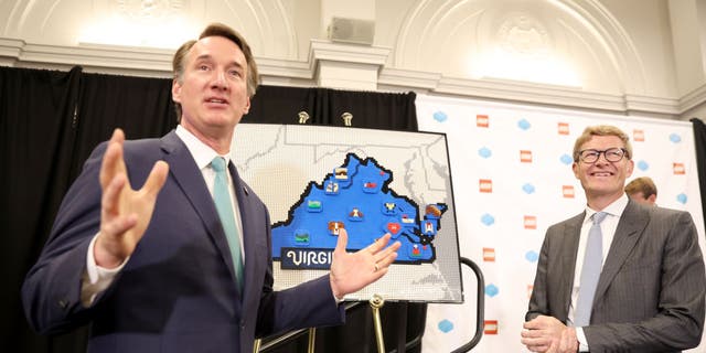 Virginia Gov. Glenn Youngkin, foreground, and Lego Group CEO Niels B. Christiansen speak during a press event during which The LEGO Group announced plans to build a $1 billion, carbon-neutral factory in Virginia.