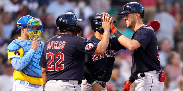 Cleveland Guardians' Nolan Jones, right, is congratulated by Josh Naylor (22) after his three-run home run during the third inning during a baseball game at Fenway Park, Tuesday, July 26, 2022, in Boston. At left is Boston Red Sox catcher Kevin Plawecki, at rear center is Guardians Andres Gimenez. 