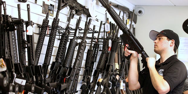 Salesman Ryan Martinez clears the chamber of an AR-15 at the Ready Gunner gun store in Provo, Utah, on June 21, 2016. REUTERS/George Frey