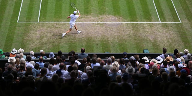 Jannik Sinner of Italy plays a forehand against Novak Djokovic of Serbia during their Men's Singles Quarter Final match on day nine of The Championships Wimbledon 2022 at All England Lawn Tennis and Croquet Club on July 05, 2022 in London, England. 