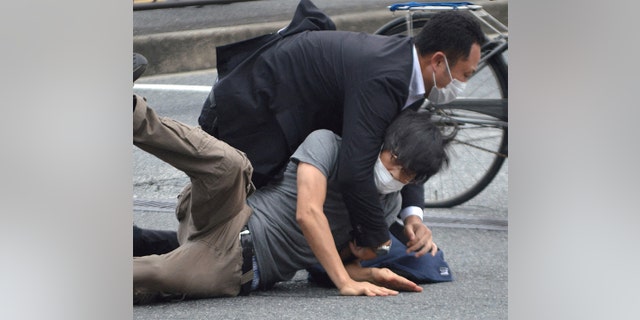 Tetsuya Yamagami is tackled bty authorities following the shooting. 