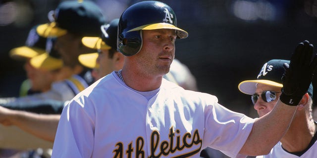 Jeremy Giambi, #7 of the Oakland Athletics, gives a high five during a game against the Chicago White Sox at the Network Associates Coliseum in Oakland, California. The Athletics defeated the White Sox 14-2.