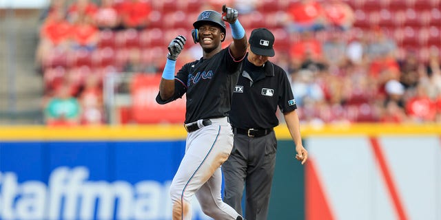 Miami Marlins' Jesus Sanchez smiles as he gestures to the dugout after hitting a double during the fifth inning of a baseball game against the Cincinnati Reds in Cincinnati, Tuesday, July 26, 2022. 