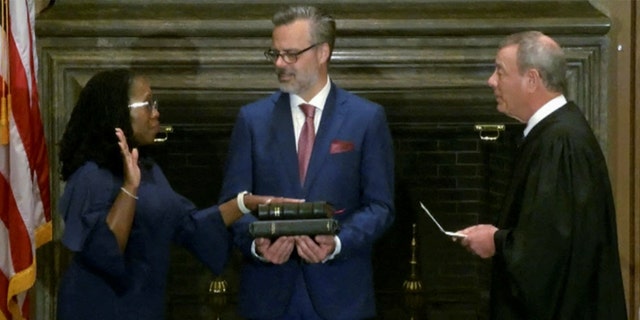 Judge Ketanji Brown Jackson is sworn in as an associate justice of the Supreme Court by Chief Justice John Roberts as Jackson’s husband Patrick Jackson holds the Bible in Washington, June 30, 2022.