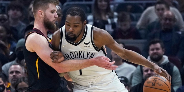The Brooklyn Nets' Kevin Durant, right, drives against the Cleveland Cavaliers' Dean Wade during a game Nov. 22, 2021, in Cleveland.
