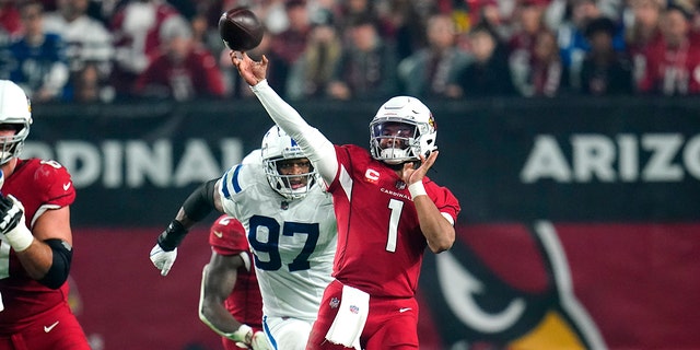 Arizona Cardinals quarterback Kyler Murray, #1, throws as Indianapolis Colts defensive end Al-Quadin Muhammad, #97, pursues during the second half of an NFL football game, Saturday, Dec. 25, 2021, in Glendale, Ariz.