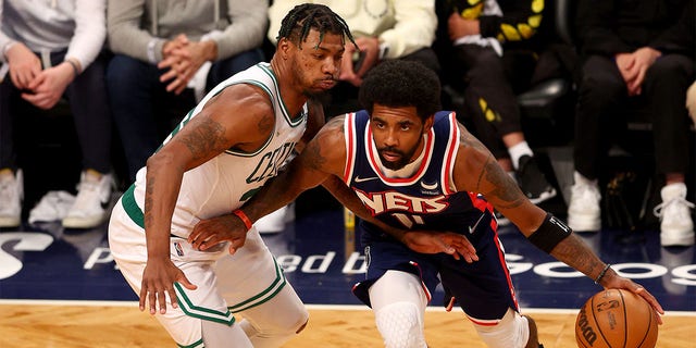 Kyrie Irving #11 of the Brooklyn Nets tries to get around Marcus Smart #36 of the Boston Celtics during Game Four of the Eastern Conference First Round Playoffs at Barclays Center on April 25, 2022 in the Brooklyn borough of New York City. The Boston Celtics defeated the Brooklyn Nets 116-112. 