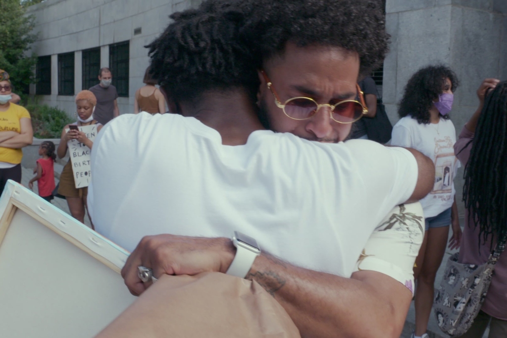 McIntyre (L) and fellow single father Omari Maynard embrace while protesting the increasing number of black maternal deaths in the country.