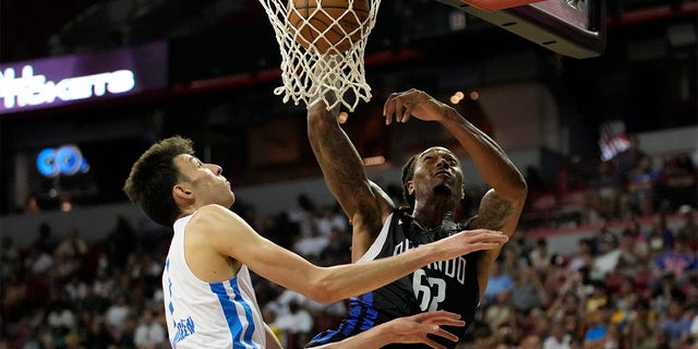 Orlando Magic's Emanuel Terry, right, dunks over Oklahoma City Thunder's Chet Holmgren during the second half an NBA summer league basketball game Monday, July 11, 2022, in Las Vegas. 