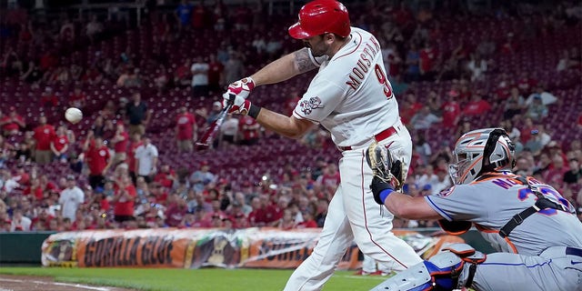 Mike Moustakas #9 of the Cincinnati Reds hits a walk-off sacrifice fly in the ninth inning to beat the New York Mets 1-0 at Great American Ball Park on July 05, 2022 in Cincinnati, Ohio. 