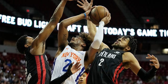 New York Knicks' Miles McBride, center, attempts a shot against Portland Trail Blazers' Brandon Williams, left, and Trendon Watford, right, during the first half an NBA summer league championship basketball game Sunday, July 17, 2022, in Las Vegas. 