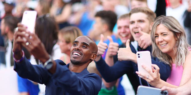 Sir Mo Farah of Team England takes a selfie photograph with fans prior to the Soccer Aid for Unicef 2022 match between Team England and Team World XI at London Stadium on June 12, 2022 in London, England.