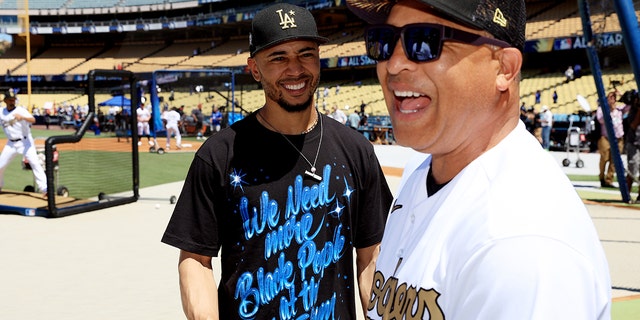 Mookie Betts #50 of the Los Angeles Dodgers speaks with manager Dave Roberts during batting practice ahead of the 92nd MLB All-Star Game presented by Mastercard at Dodger Stadium on July 19, 2022 in Los Angeles, California.