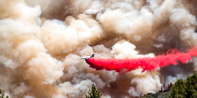 An air tanker drops retardant while trying to stop the Oak Fire from progressing in Mariposa County, Calif., on Sunday, July 24, 2022. 