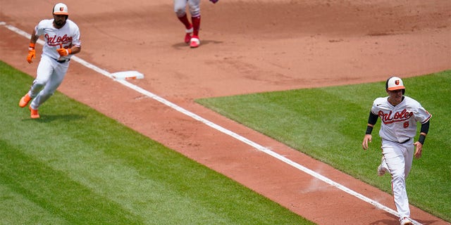 Baltimore Orioles' Ryan Mountcastle (6) runs home with teammate Anthony Santander (25) behind him as they both score on a single by Ramon Urias during the fourth inning of a baseball game against the Los Angeles Angels, Sunday, July 10, 2022, in Baltimore. 