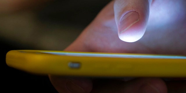 In this Sunday, Aug. 11, 2019, photo, a man uses a cell phone in New Orleans. Quick help for suicidal thoughts and other mental health emergencies may soon be as easy as 9-8-8. The United States’ first nationwide three-digit mental health crisis hotline goes live on Saturday, July 16, 2022. 