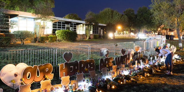 A woman visits at a memorial at Robb Elementary School in Uvalde, Texas, on Wednesday, June 1, to pay her respects to the victims killed in last week's school shooting.