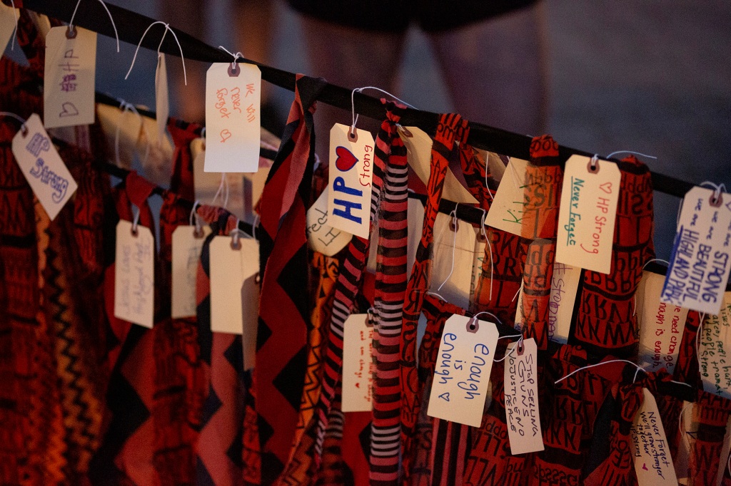 People add strips of cloth with names and phrases memorializing the victims of the Highland Park shooting on the Fourth of July. 