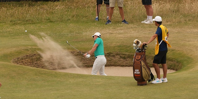 Rory McIlroy of Northern Ireland hits out of the bunker on the 10th green during the third round of the British Open on the Old Course at St. Andrews, Scotland, Saturday, July 16, 2022.