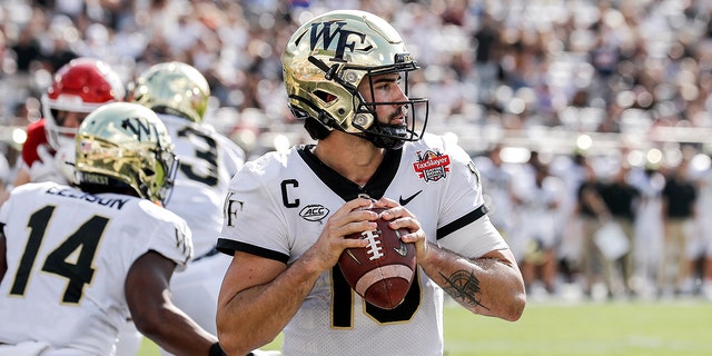 Quarterback Sam Hartman (10) of the Wake Forest Demon Deacons sets to pass against the Rutgers Scarlet Knights at the 77th annual TaxSlayer Gator Bowl at TIAA Bank Field Dec. 31, 2021, in Jacksonville, Fla.