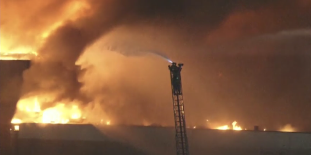 A firefighter battles a major warehouse fire in Los Angeles. 