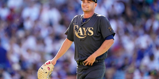 American League starting pitcher Shane McClanahan, of the Tampa Bay Rays, smiles as he walks back to the dugout during the first inning of the MLB All-Star baseball game against the American League, Tuesday, July 19, 2022, in Los Angeles.