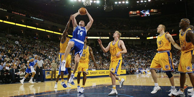 Stanislav Medvedenko #14 of the Los Angeles Lakers shoots against the Golden State Warriors during an NBA game at the the Arena in Oakalnd on December 23, 2003 in Oakland, California.  The Warriors won 107-98.  