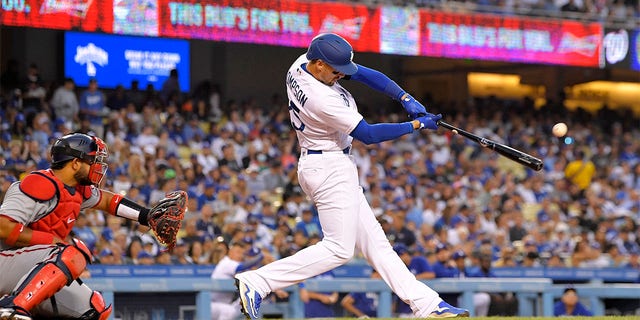 Los Angeles Dodgers' Trayce Thompson, right, hits a solo home run as Washington Nationals catcher Keibert Ruiz watches during the third inning of a baseball game Monday, July 25, 2022, in Los Angeles. 