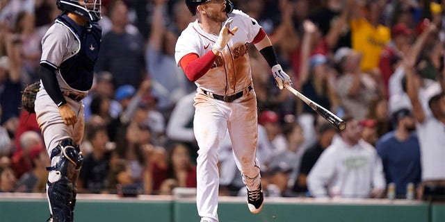 Boston Red Sox's Trevor Story, right, hits a three-run double as New York Yankees' Jose Trevino, left, looks on in the seventh inning of a baseball game, Sunday, July 10, 2022, in Boston. The Red Sox won 11-6. 