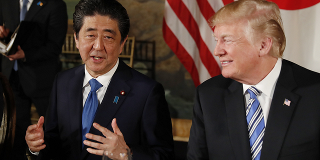 U.S. President Donald Trump looks on as Japan's Prime Minister Shinzo Abe speaks while dining at Trump's Mar-a-Lago estate in Palm Beach, Florida, on April 18, 2018.